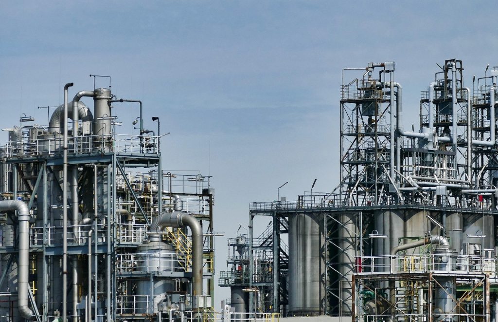 Instalacje i zbiorniki zakładu chemicznego na tle błękitnego nieba.
