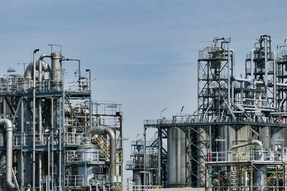 Instalacje i zbiorniki zakładu chemicznego na tle błękitnego nieba.
